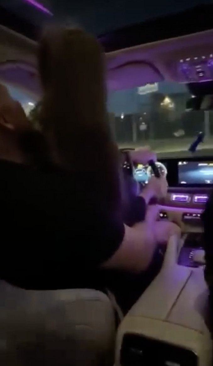 Plinta įrašas, kaip galimai BMW nesuvaldžiusi mergina sėdi vyrui ant kelių ir mokosi vairuoti